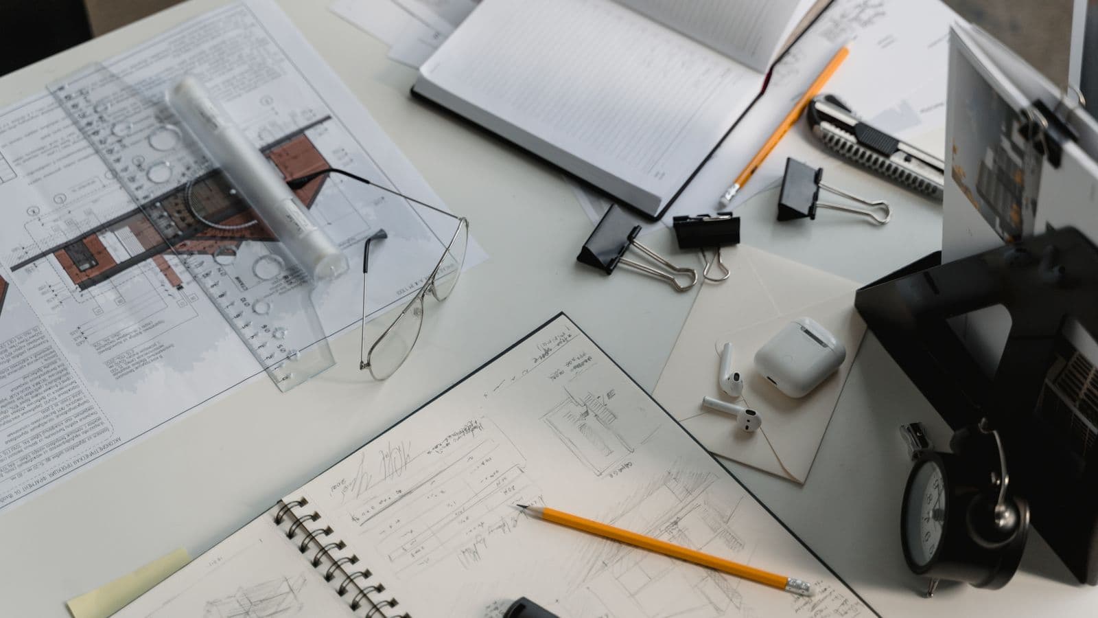 Plans d'architecte, croquis et outils de dessin sur un bureau — chiffrer un projet de site internet pour PME